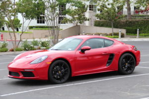 2018 Porsche 718 Cayman base model in Carmine Red photographed from front 3/4 profile