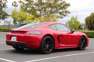 2018 Porsche 718 Cayman base in Carmine Red color photographed from rear 3/4 angle