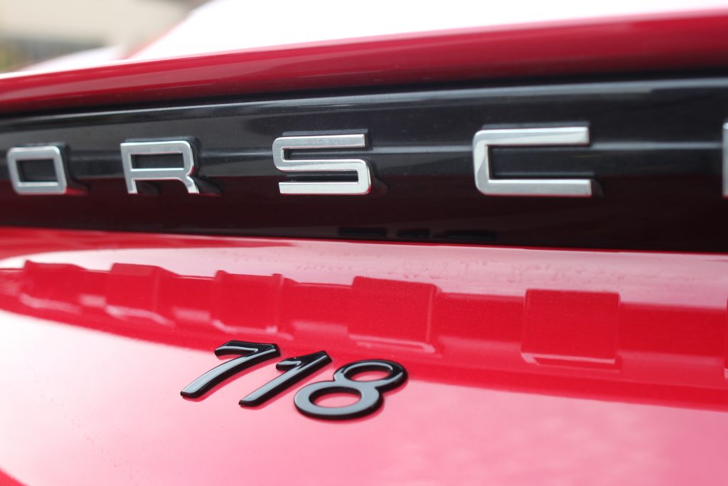 A rear of a 718 Cayman showing the "Porsche" and "718" logos