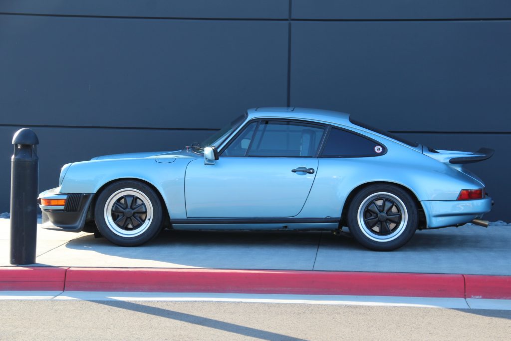 Porsche 911 classic in light blue , side profile