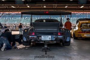 RWB Porsche 930 in grey with the rear jacked up, shown from the rear in a garage at Twin Ring Motegi Circuit, Japan