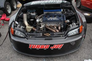 The front of a drag racing prepared Honda Civic hatchback, showing the all-motor modified engine