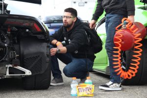 A young gentleman checks the tire pressure of a Lamborghini Huracan