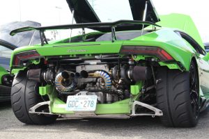 A Lamborghini Huracan in green with its rear bumper removed, showing its twin turbochargers and custom titanium exhaust