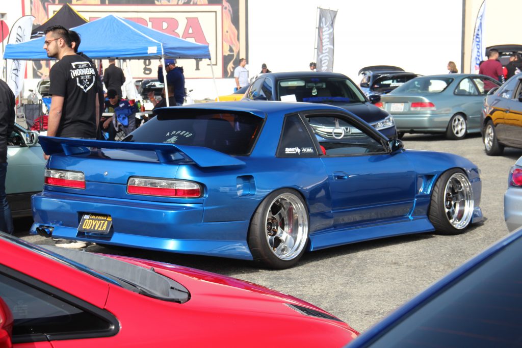 A Nissan 240SX/Silvia, in blue, with aggressive polished wheels, at a car show