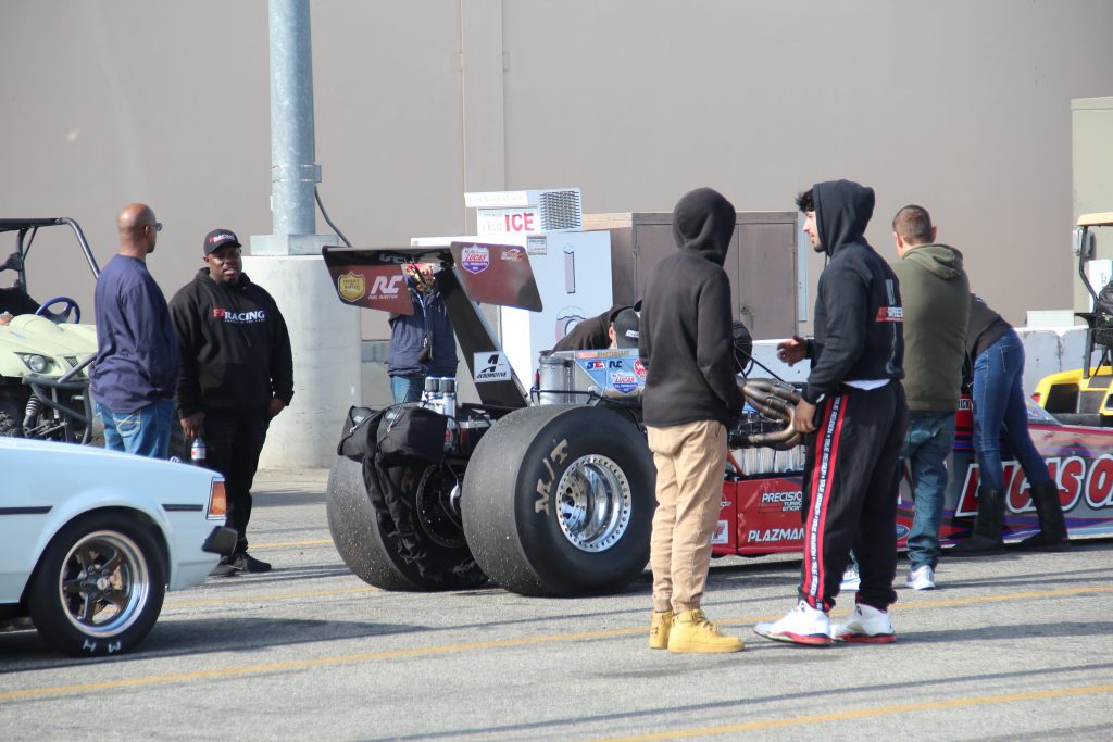 Fans observe a Top Fuel dragster awaiting its turn to run at Autoclub Speedway