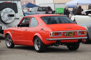 A classic Toyota Corolla SR5 with custom orange paint