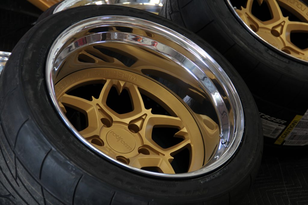 A close-up shot of a deep-dish Rotiform wheel with a silver face and polished lip.