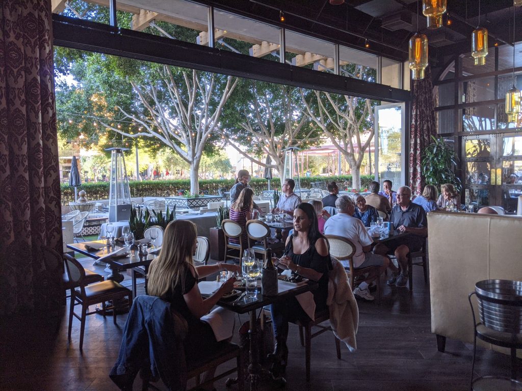 Taken from inside Olive & Ivy restaurant in Scottsdale, Arizona, showing the exterior of the restaurant open to the outside area.
